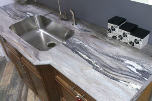 White under-mount kitchen sink on a brown, grey, and white laminate countertop in a kitchen in Springfield, IL.