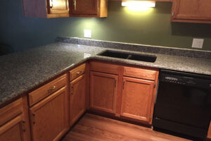 Residential kitchen with brand new granite countertops, light wood cabinets, and under cabinet lighting done by a professional in Taylorville, IL.