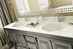 A black dual sink vanity with white cultured marble countertops for a residential bathroom in Taylorville, IL.