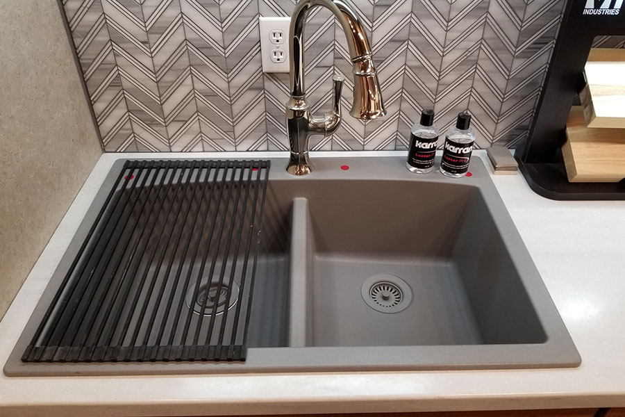 A quality dual sink for a residential kitchen with a roll-up rack and tile backsplash in Springfield, IL.