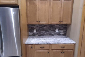 Grey and white tiled backsplash for a kitchen with light wood cabinets and stainless steel appliances in Springfield, IL.