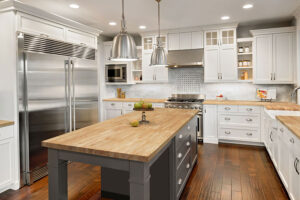 A rustic kitchen with white cabinets and a butcher block countertop and island in Glenarm, IL.