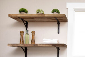 Wooden floating shelves with black legs for a residential bathroom in Glenarm, IL that replaced old cabinets.