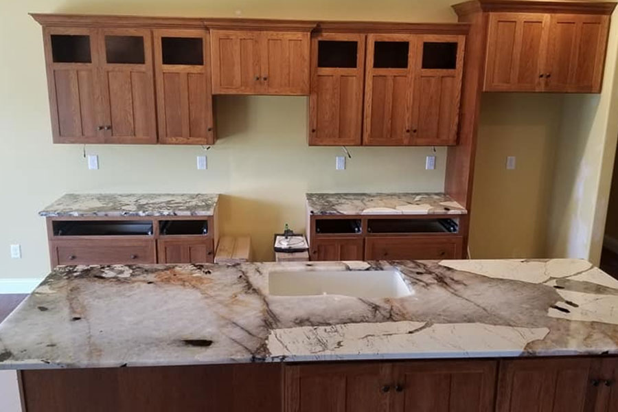 Quality stone countertop installation service for a residential kitchen with brown cabinets in the Glenarm, IL area.