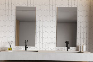 A modern bathroom with white hexagon tiles and black grout in Glenarm, IL. This bathroom has a floating double vanity sink with black faucet hardware.