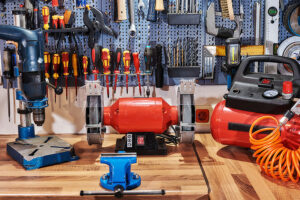 Red and blue tools sitting on a laminate countertop in Glenarm, IL that has been installed by professional countertop experts for a garage workspace.