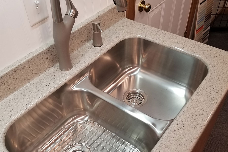 A dual basin sink with a sink grid in the first basin in a home in Glenarm, IL. Also, a kitchen sink grid from Karran in a kitchen with a granite countertop.