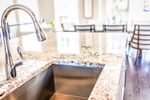 A stainless steel faucet with a single basin sink and a granite countertop in Glenarm, IL that has been cleaned with Granite Gold®.