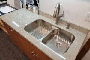 A solid surface countertop for a kitchen with a dual basin sink in Ray's Countertop Shop's warehouse in Glenarm, IL.
