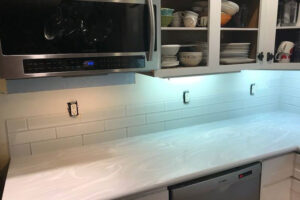 A white solid surface countertop in a residential kitchen in Springfield, IL with a subway backsplash and stainless-steel appliances.