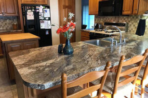 A brown and tan kitchen countertop installed by Ray’s Countertop Shop in Glenarm, IL. A custom countertop with a double basin sink.