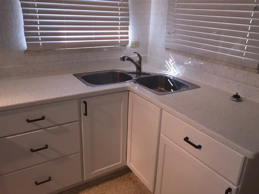 Ray's Countertop Shop Inc. - previous work, speckled solid surface countertop, with white laminate cabinets, and double-bowl corner kitchen sink - Springfield, IL