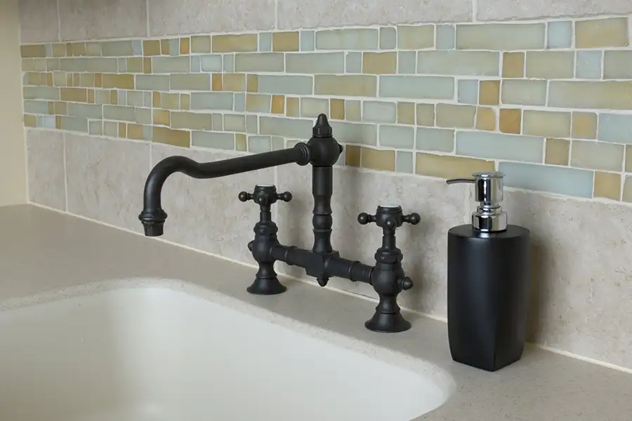 Tile backsplash in a bathroom behind a sink and faucet in a Springfield, IL resident's home.