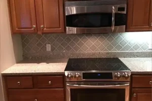 RAY'S COUNTERTOP SHOP INC. - Close-up picture with a countertop with a geometric tile backsplash in the kitchen of a Springfield, IL home.