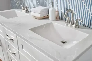 RAY'S COUNTERTOP SHOP INC. - White marble cultured countertop behind a blue tile backsplash in the bathroom of a Springfield IL, home.